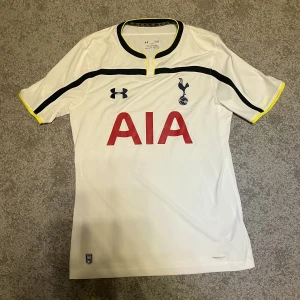 Tottenham fotbollströja - Tottenham fotbollströja från 2014/2015 säsongen. Tröjan är använd några gånger men den är inte skadad på något sätt trots att den är runt 8 år gammal. Alltså är den i bra skick och äkta. Pris kan diskuteras.