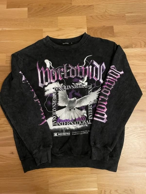 Sweatshirt med tryck - Snygg mörkgrå/svart sweatshirt med lila och vit design! Använd fåtal gånger, i bra skick. Storlek M!