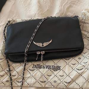 En svart zadig & Voltaire väska med silvriga detaljer. Kommer med ett kort band och ett långt, samt dess ursprungliga dustbag. Väskan är i väldigt gott skick. Nypris:3500kr.