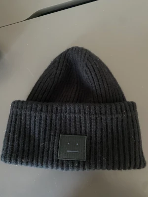 Acne mössa - En super fin acne mössa i färgen svart. Den är knappt använd o perfekt nu till vintern när det är kallt ute. Köp direkt för 650