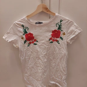 New Yorker, S - En vit t-shirt med en broderad blomma och humla. Den är i bra skick.  25kr+frakt