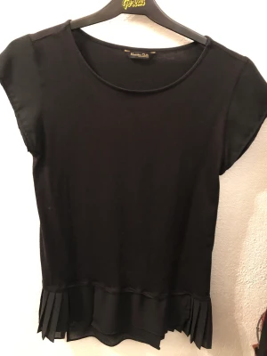 T-shirt topp Massimo Dutti - Svart topp med tunn skrynklad volang nedtill. Kul detalj