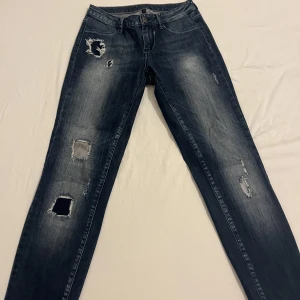 Låg midja jeans - Dessa jeans är från vila clothes. De är blåa med lite hål ( de ska va så) de är även låg midjade. De är från 2006 talet men håller fortfarande kvaliten. Jeansen är i storlek M.