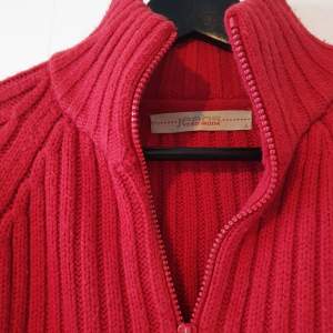 Stickad, röd tröja från Vero Moda med dragkedja. Storlek L