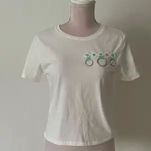Helt oanvänd vit t-shirt med blom-detaljer i storlek S för 25kr. 💗