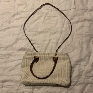 Handväska - Säljer min beigea handväska/crossbodybag! Den är gjord på manchester-liknande material och den har små piggar på botten! Köpt secondhand, skriv gärna frågor❤️