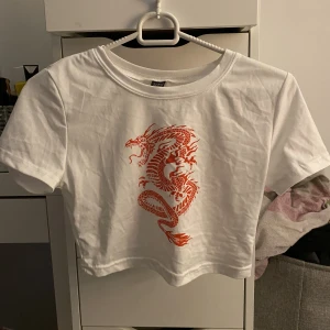 Topp med tryck  - En vit topp med rött tryck, oanvänd från shein. Mjukt material, strl S. Säljer för 25kr+frakt