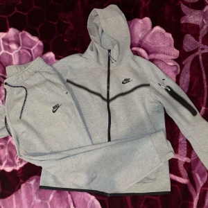 Nike Tracksuit gråa storlek M-S - Hej,jag säljer min brorsas tryck suit som är köpt nu i december 2022 han säljer den för att han beställde fel storlek och han var bortrest så han kunde inte skicka tillbaka den!! Fler bilder om ni kontaktar mig!!
