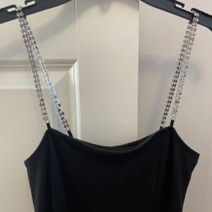 Svart klänning - Svart kort klänning med slits och diamant straps. Köpt från hm i st XS