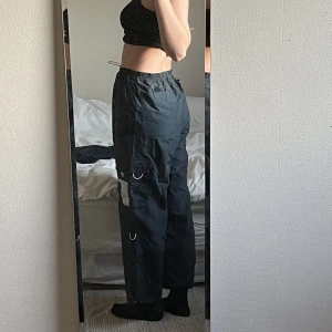 FILA parachute pants -   Marinblåa fila typ parachute pants som man kan göra om till shorts, dock är de uppsprätta längst ner, går ner till golvet om man har lowwaist iallafalla på mig som är 167. Passar typ alla storlekar för man kan ändra i midjan.