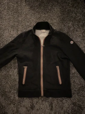 Moncler cardigan  - Tjo säljer nu denna moncler cardigan! Storlek L i lappen men sitter som en S den är i bra skick🙌 hör av er vid frågor eller funderingar