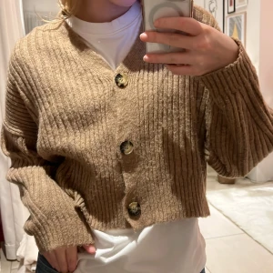 Stickad kofta - Brun stickad kofta från Chiquelle. Jättemysig och skön. Lite croppad. Kan användas både som tröja och kofta! Stl står ej men skulle tippa på XS/S. Jättebra skick!