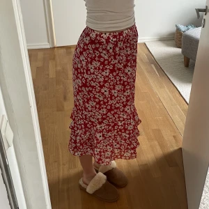 Kjol - Superfin blommig kjol från Vila i storlek 36. Den är röd med fint blommönster och har en underkjol så den är ej genomskinlig.
