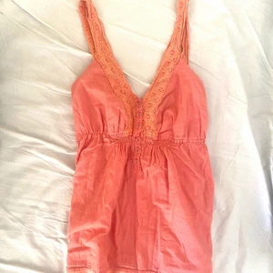 Somrig topp - Jättefint linne i rosa/korall med spetsdetaljer. Har resår i bysten så kan passa många storlekar