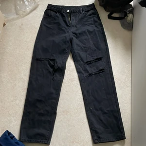 Svarta jeans - Svarta vida jeans med hål på båda benen, aldrig anvädda. 