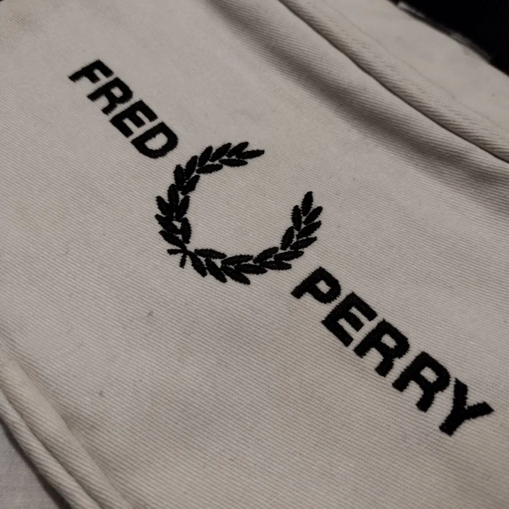 Fred Perry Mens Graphic Waist Bag . Embroidered branding. 100% polyester. Zip fastening main compartment and front pocket. Adjustable strap with clip. Size: 36x16x8cm approx.. Väskor.