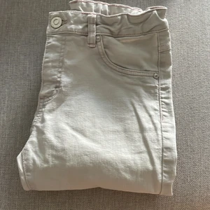 Superstiliga Jeans - Snygga och stiliga Vita Jeans med ljusrosa detaljer och slitsade ändar med dragkedja.