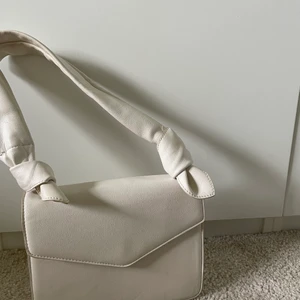 Vit axelväska från NA-KD  - Vit axelväska med ett stort och ett litet fack. Finns ett längre band till💕