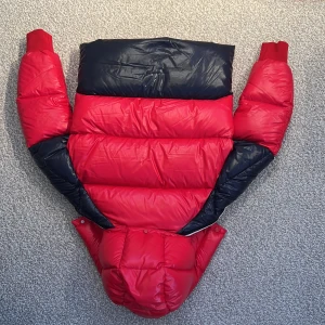 Röd,mörkblå vinter moncler jacka.  - Den ser ut som den är helt ny köpt. Den är varm och väldigt skön att ha på sig. Storlek är 12-14 år. Men man kan nog max vara 177 cm om man vill att den ska passa bra