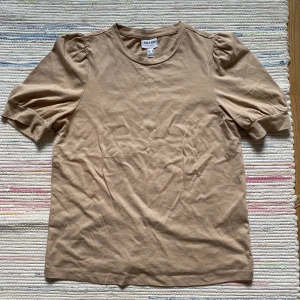 Beige/Brun T-shirt - Söt brun t-shirt som passar till allting. Den är inte genomskinlig och i storlek S. Köparen står för frakten menar det går att mötas upp. TRYCK EJ PÅ KÖP NU!