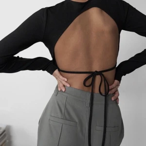 Svart topp med öppen rygg - Sjukt snygg långärmad topp med öppen rygg. Passar perfekt till vardags och festliga tillfällen🙌🏼Säljer då den bara hängt på galgen, så i nyskick!