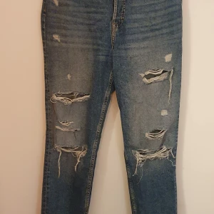 Ripped jeans - Ett par ripped jeans från H&M med knappgylf, använda några få gånger men inget som märks