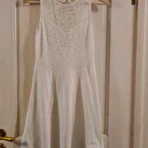 Klänning Even&Odd S - Vit klänning från Even&Odd i storlek S. Spets upptill och öppet hål i nacken. Aldrig använd men bortklippt lapp. Nyskick!  Frakt tillkommer med 39 kr 🌞