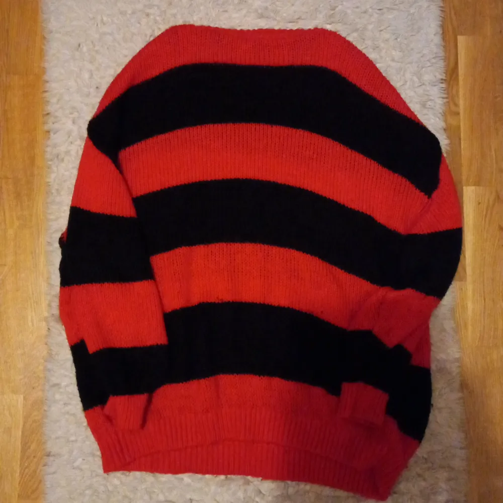 En svart- och rödrandig tröja i storlek large.  knappt använd och fortfarande helt ny! snälla SMSA först innan du köper artikeln!. Stickat.