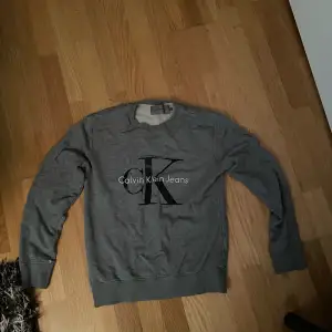 Calvin Klein grå tröja, i skicket 8/10. Köpt för många år sen och inta använts på länge, denna populära modell har slutats sälja av Calvin Klein. 