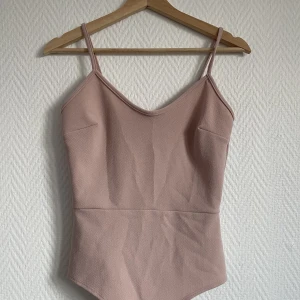 Body  - Nude rosa body ifrån Nelly Två knappar vid skrevet som man knäpper med  Super fin och skön men jag har inga tillfällen andvända den tyvärr 
