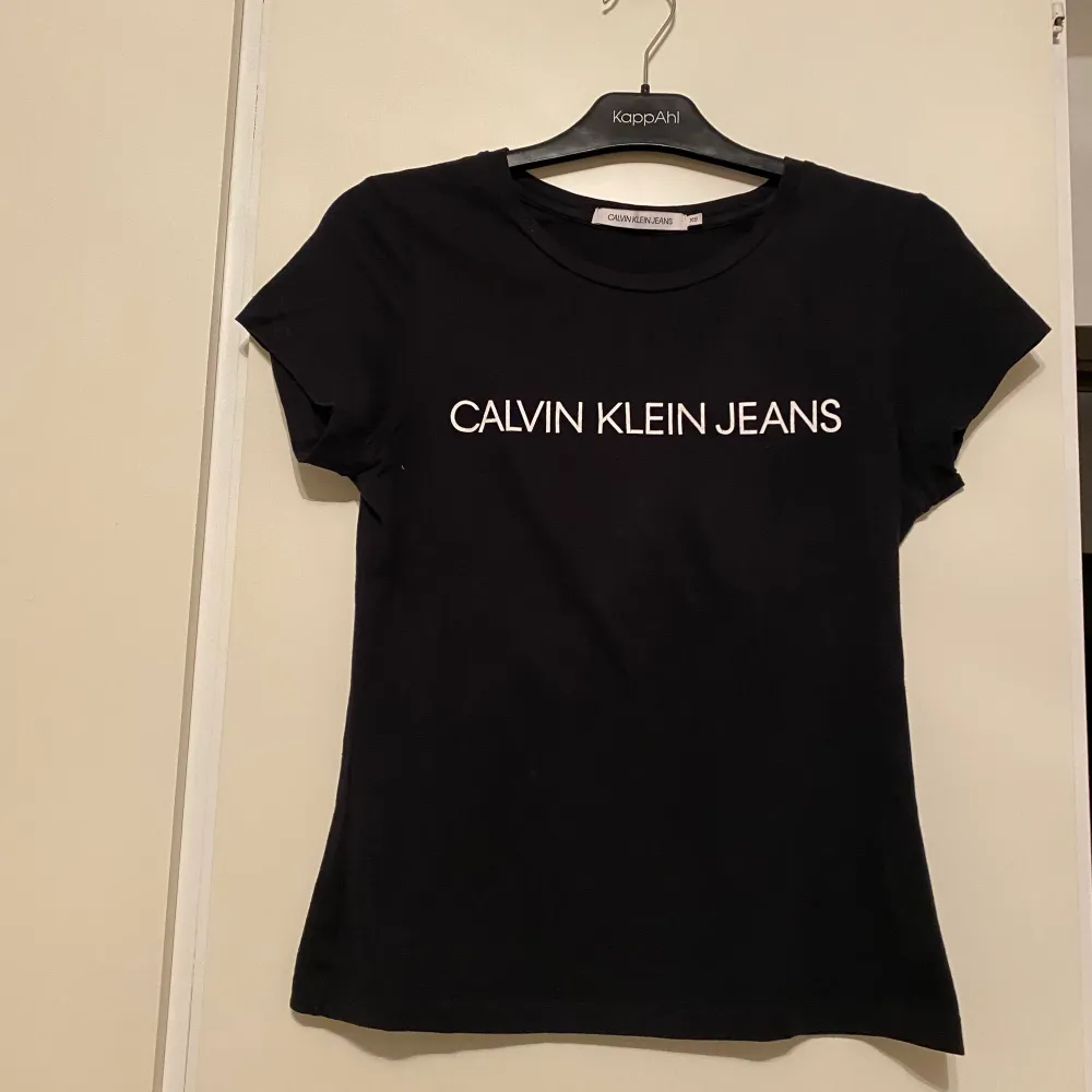 En svart t-shirt med vitt tryck på brösten från Calvin Klein. Enbart använd vid att tillfälle. . T-paidat.