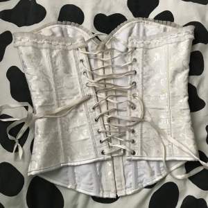 En vitt corset med snören på baksidan 