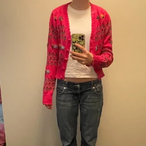 Stickad tröja  - Rosa stickad tröja med broderade blommor på. Jättefin och bra kvalite. Skönt material men kommer tyvärr inte till användning.