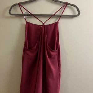 Lila topp - Säljer en jättefin lila topp! Den är köpt från second hand men jag har aldrig använt den, tror att den ursprungligen är från New yorker ❤️ Den kan bäras åt båda hållen, antingen med korsade band i fram eller i ryggen, supersnyggt! Frakt tillkommer.