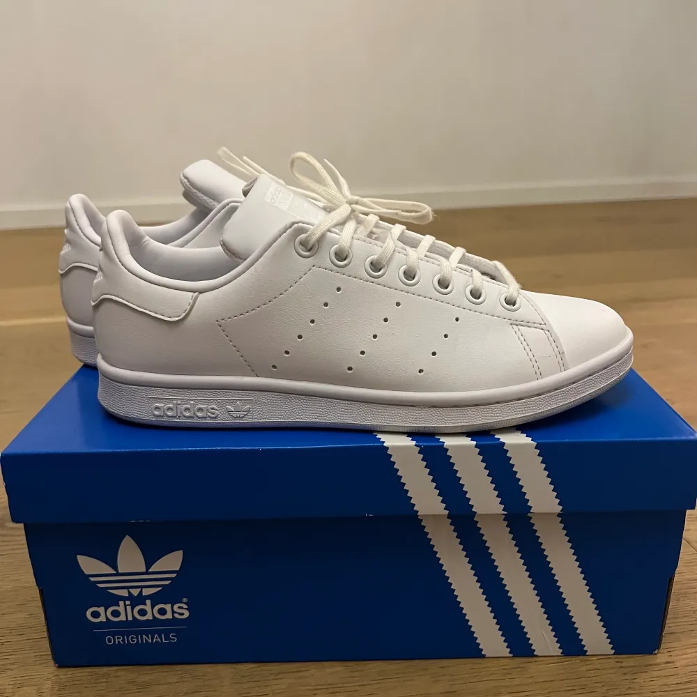 Vita Adidas skor i modellen stan smith. Köpta för cirka två månader sedan för 1095kr. Knappt använda som ni ser på bilden (max 2 gånger). Ser helt nya ut. Pris nan diskuteras.. Skor.