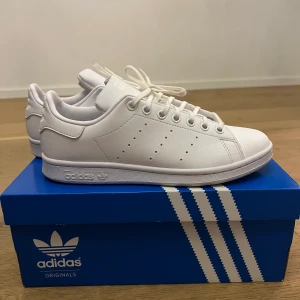 Adidas skor  - Vita Adidas skor i modellen stan smith. Köpta för cirka två månader sedan för 1095kr. Knappt använda som ni ser på bilden (max 2 gånger). Ser helt nya ut. Pris nan diskuteras.