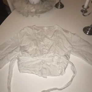 Skjorta - En vit skjorta man knyter runt magen skriv för bilder due den sitter på, storlek S 