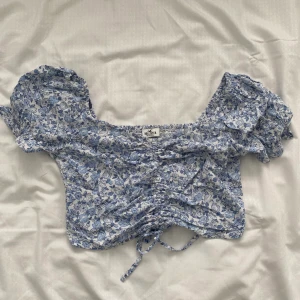 Blommig topp - Blommig topp från hollister! Använd en gång på en födelsedag. Säljer den då jag inte använt den på över ett år.  Tryck ej på köp nu :)
