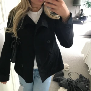 Kort trenchcoat / kort kappa - Så snygg croppad trenchcoat! Perfekta höstjackan! Gammal modell från Hm i storlek 42 men sitter som en 36/38 ! Är i jeansmaterial och har flertal knappar💕💕 köparen står för frakt på 66kr❤️‍🔥❤️‍🔥