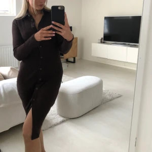 Stickad klänning från H&M - Jättefin mörkbrun stickad klänning från H&M. Superfin på med kanppar fram så man kan bestämma hur öppen man vill ha den. Möts helst upp i Stockholm men finns möjlighet att få den skickad också mot en fraktsumma 🥰