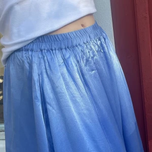 WEEKDAY satinkjol 💧 - Vacker himmelsblå satinkjol från weekday. Två fickor. Resårband. Nypris: 400 kr. Bra skick, inte använts så mycket. Säljes för 100 kr exklusive frakt pga används ej. Storlek 36. Modell storlek 36/38.