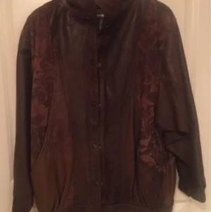 Skinnjacka i retromodell Stl:10/36-38 - Retro jacka i jättefint skinn. Bruno Collection.  Oanvänd stl:10  Olika bruna toner och mönster. Randigt tunt foder.  Den är köpt i England på 80-talet. Fler bilder finns.  Vill du ha mått uppgifter hör av dig.