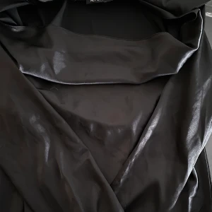 Svart klänning i glatt material från NLY ONE, strl S - Svart klänning med långa ärmar med slit vid handlederna från NLY ONE, strl S. Använd ett fåtal gånger så bra skick! Köparen står för frakt🌻