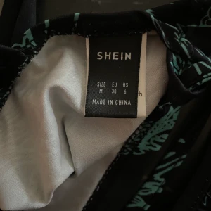 Matchade set från Shein, strl M/38 - Matchade set från Shein, topp med justerbar snörning i ryggen och kjol med slits. Mjukt och stretchigt tyg, endast provad så nyskick. Kan säljas separat. 250 tillsammans, eller 150kr separat per plagg. Köparen står för frakt🌻