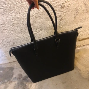 Snygg rymlig väska - Rymlig väska i skinnimitation med fack till mobil och ett fack med dragkedja. Höjd: 34cm, längd 45cm