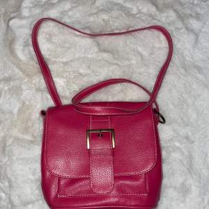 ”Vintage” väska i hot pink färg. Perfekt storlek för att få plats med det viktigaste. Använt skick.