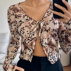Mönstrad topp med knytning - ❣️Leopardmönstrad topp med knytning framtill❣️Storlek: 32/34 (lapp sitter ej kvar så osäkert) ❣️Skick: använd endast en gång❣️
