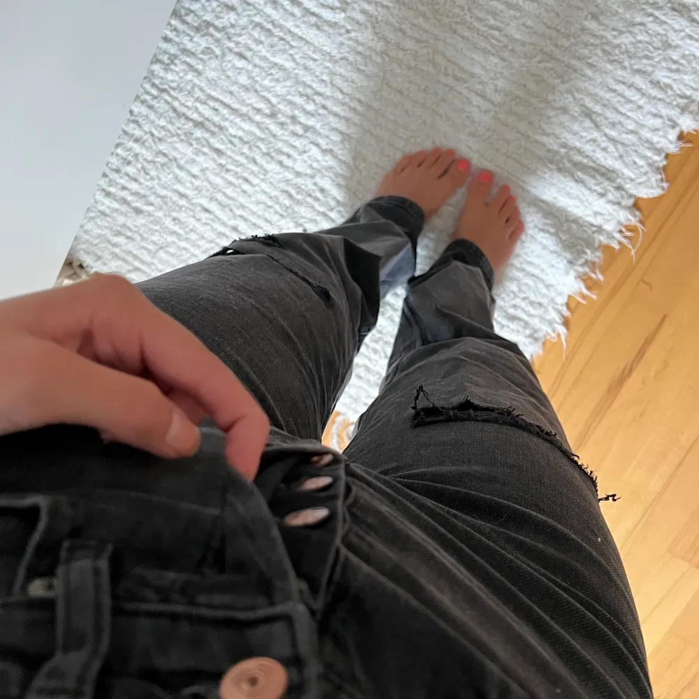 Raka svarta jeans med slitningar från h&m. De har knappar istället för gylf och sitter väldigt bra, framhäver former. Jeansen är i nyskick!. Jeans & Byxor.