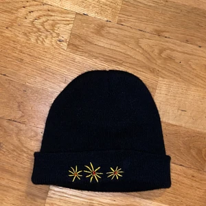 Svart Beaine med motiv - Enkel Beanie med motiv. Använd få gånger. Bra skick. Passar till mycket.