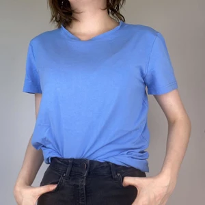 Blå T-shirt  - Simpel blå T-shirt. Köpt secondhand men nästintill oanvänd. Säljer då den inte kommer till användning.  Köpare står för frakt. Tar emot Swish eller direktbetalning via app. Kan också mötas upp i Växjö.